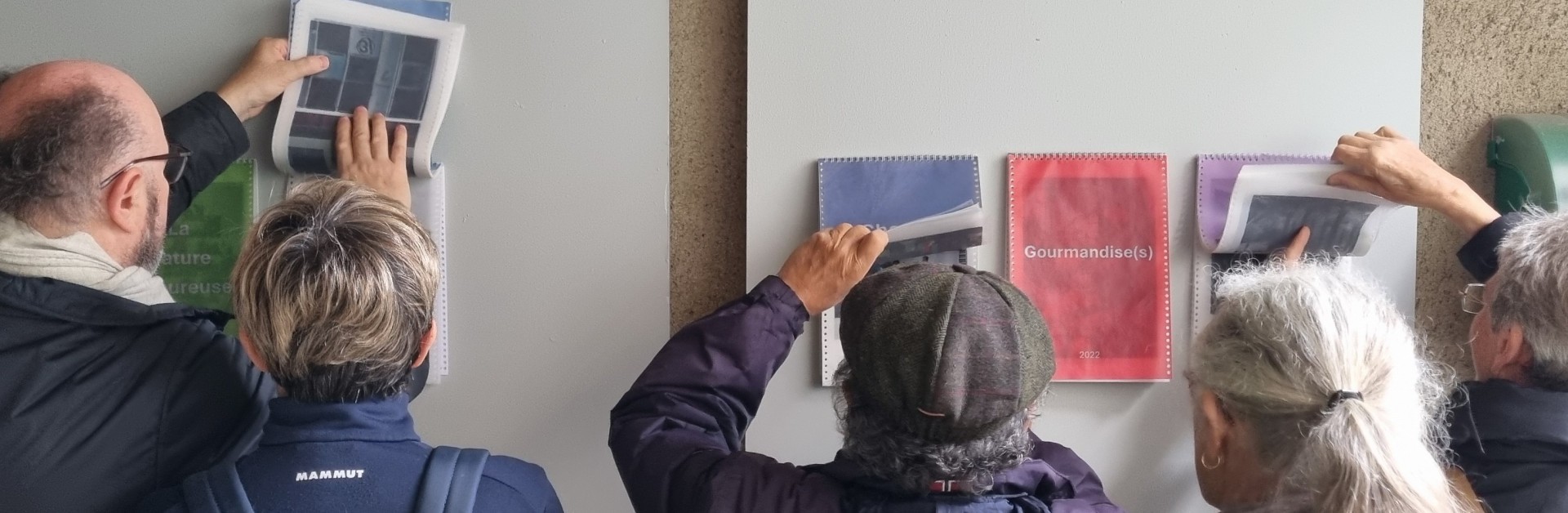 Visiteurs au vernissage de l'exposition "Cycle(s)" des adultes de l'atelier de l'imaginaire recadrant les oeuvres