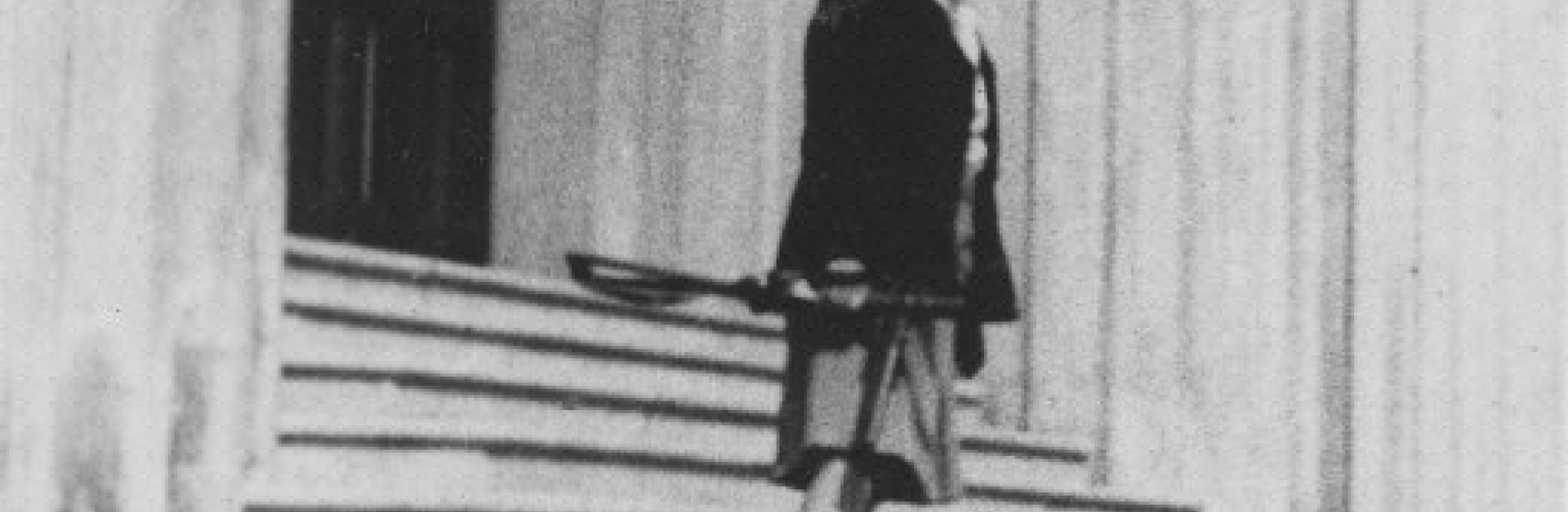 Photographie en noir et blanc d'une femme se tenant debout sur des escaliers