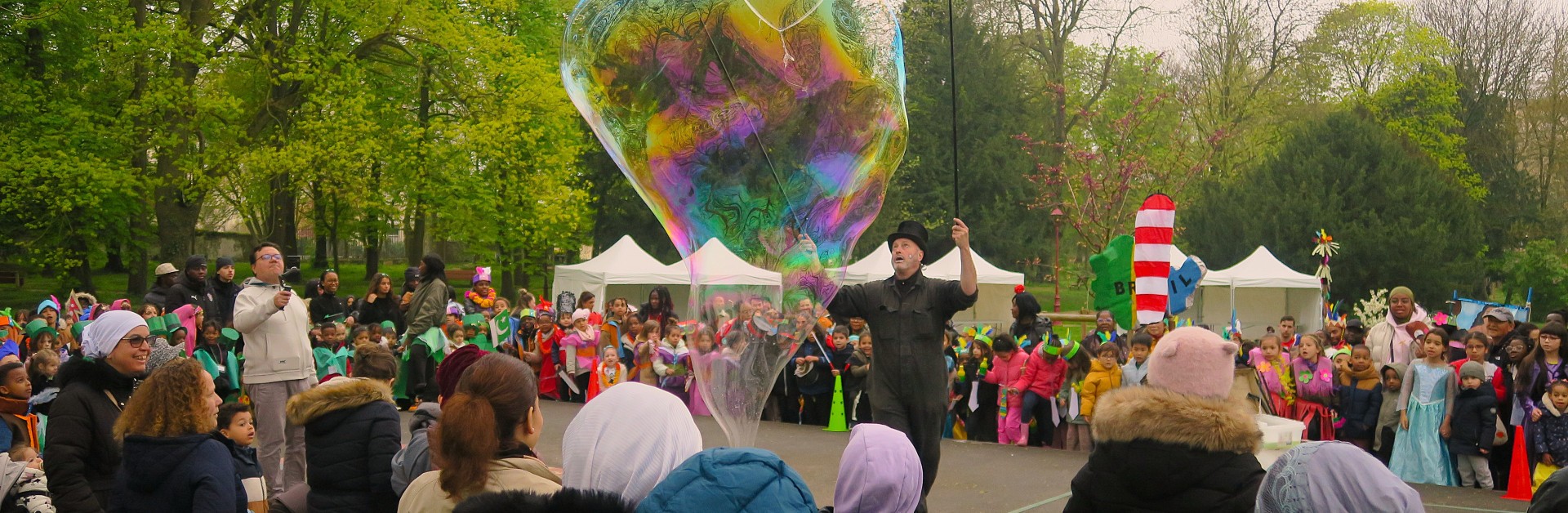 Scène du carnaval de 2026 avec des enfants regardant un spectacle de bulles