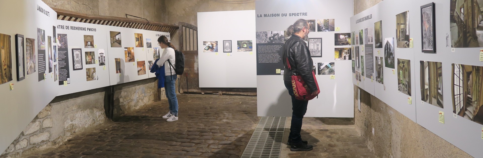Deux visiteurs dans l'exposition "Urbex, racines et fragments"