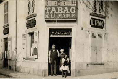 Un homme, une femme et un enfant posant sur le pas de porte du tabac de la mairie de Fresnes - Agrandir l'image 3 sur 8, fenêtre modale