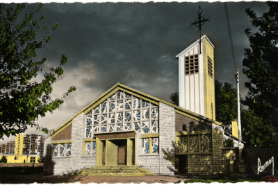 Vue de la nouvelle église Notre-Dame de la Merci de Fresnes, entourée d'arbre et sous un ciel nuageux - Agrandir l'image 10 sur 20, fenêtre modale