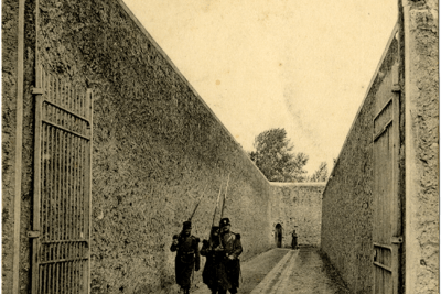 Carte postale montrant des gardiens marchant dans le chemin de ronde de la prison de Fresnes - Agrandir l'image 1 sur 15, fenêtre modale