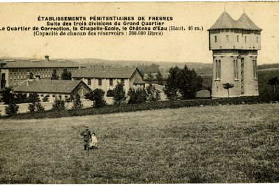 Un homme et un enfant marchant dans un champs, et au second plan, certains bâtiments de la prison de Fresnes : le quartier de correction, la chapelle école et le château d'eau - Agrandir l'image 10 sur 15, fenêtre modale