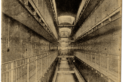 Vue d'une division : un grand couloir, sur plusieurs étages, regroupant les portes des cellules - Agrandir l'image 15 sur 15, fenêtre modale