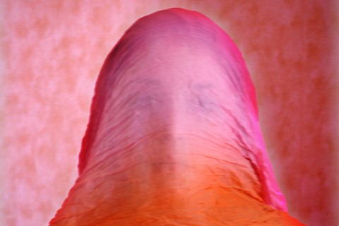 Visage d'une femme à moitié caché par un voile fin rose et orange