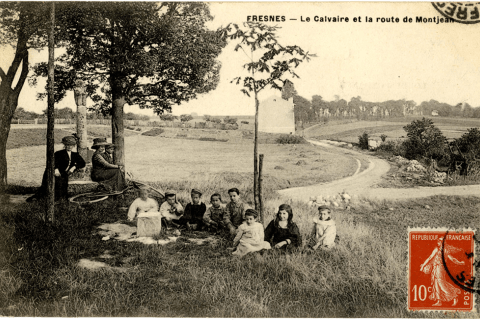 Femmes et enfants assis dans l'herbe au calvaire de la route de Montjean de Fresnes