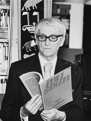 Un homme aux cheveux blancs avec des lunettes lit une publication : "Museum, Musée et environnement" - Agrandir l'image, fenêtre modale
